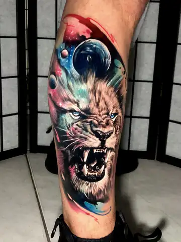 Leão rugindo com juba em galáxia e planetas coloridos, tatuagem art fusion na panturrilha