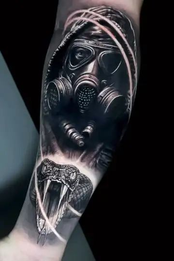 Figura com máscara de gás e serpente com presas, tatuagem em realismo preto e cinza no antebraço