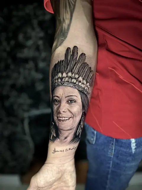 Retrato de mãe com cocar em realismo no antebraço